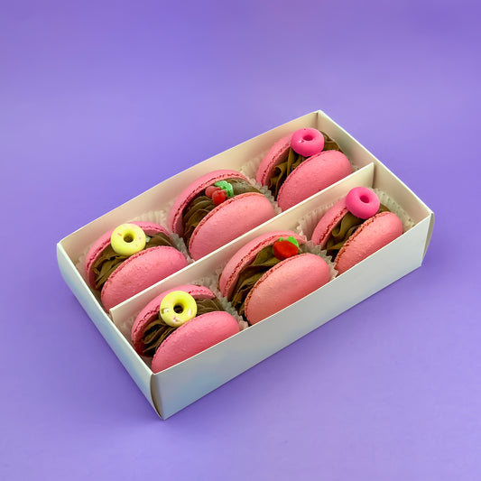 Cherry Chocolate Macarons Box with 6 premium pink macarons filled with dark chocolate ganache and cherry compote, beautifully packaged in a golden box with a clear window.